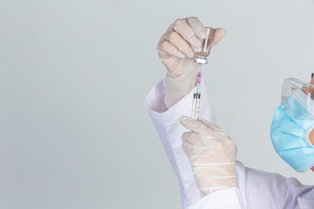 young-doctor-is-holding-hypodermic-syringe-with-vaccine-vial-rubber-gloves-on-gray-wall.jpg