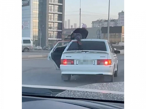 Красноярец залез на крышу Lada и прокатился по городу. Скриншот видео: ЧП Красноярск